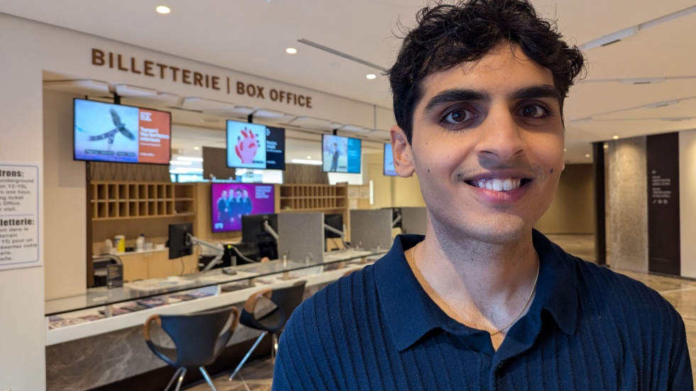 Un jeune homme sourit devant la Billetterie du CNA
